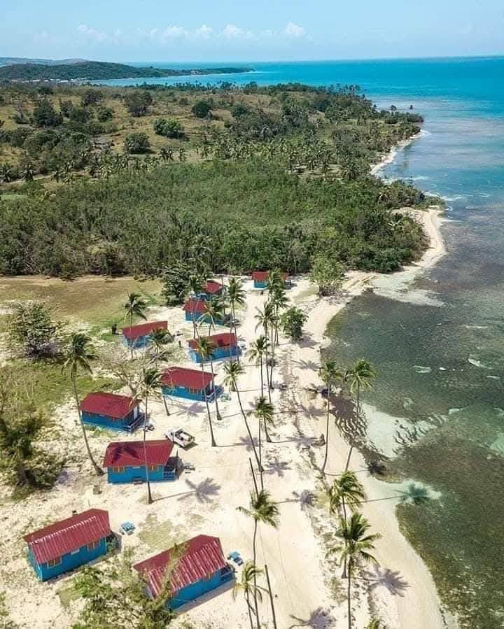Vista aérea de las cabañas de Villa La Mela desde arriba con agua turquesa